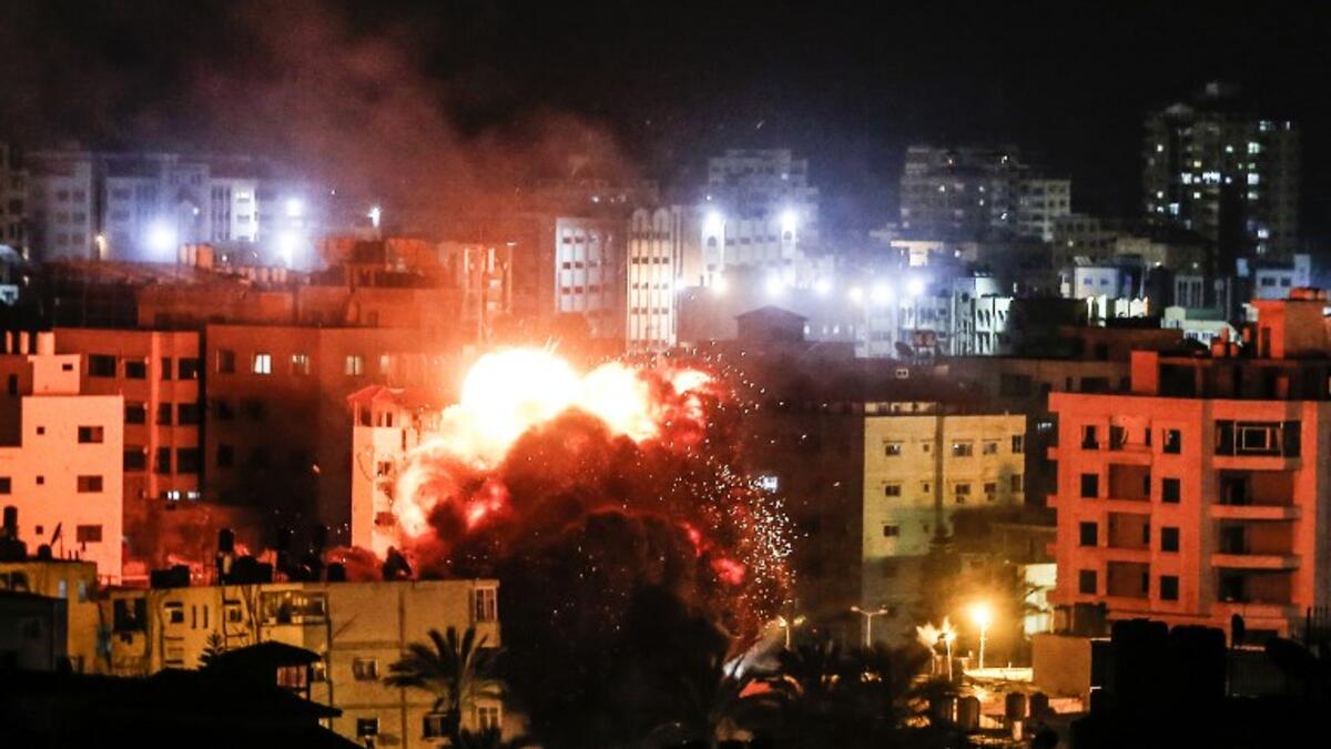 Fire and smoke billow above buildings in Gaza City during reported Israeli strikes on March 25, 2019. Israel's military launched strikes on Hamas targets in the Gaza Strip today, the army and witnesses said, hours after a rocket from the Palestinian enclave hit a house and wounded seven Israelis.
Mahmud Hams / AFP