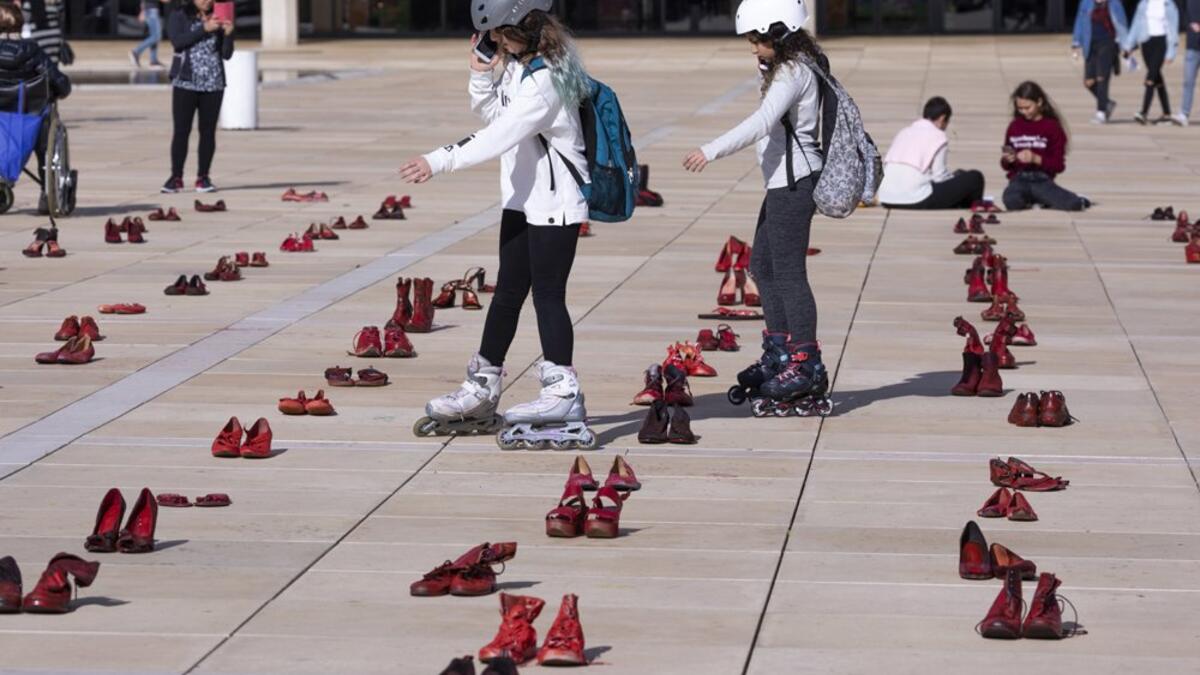 Israelis walk past an installation of red shoes during a rally against domestic violence in the Israeli coastal city of Tel Aviv on December 4, 2018 (Twitter)