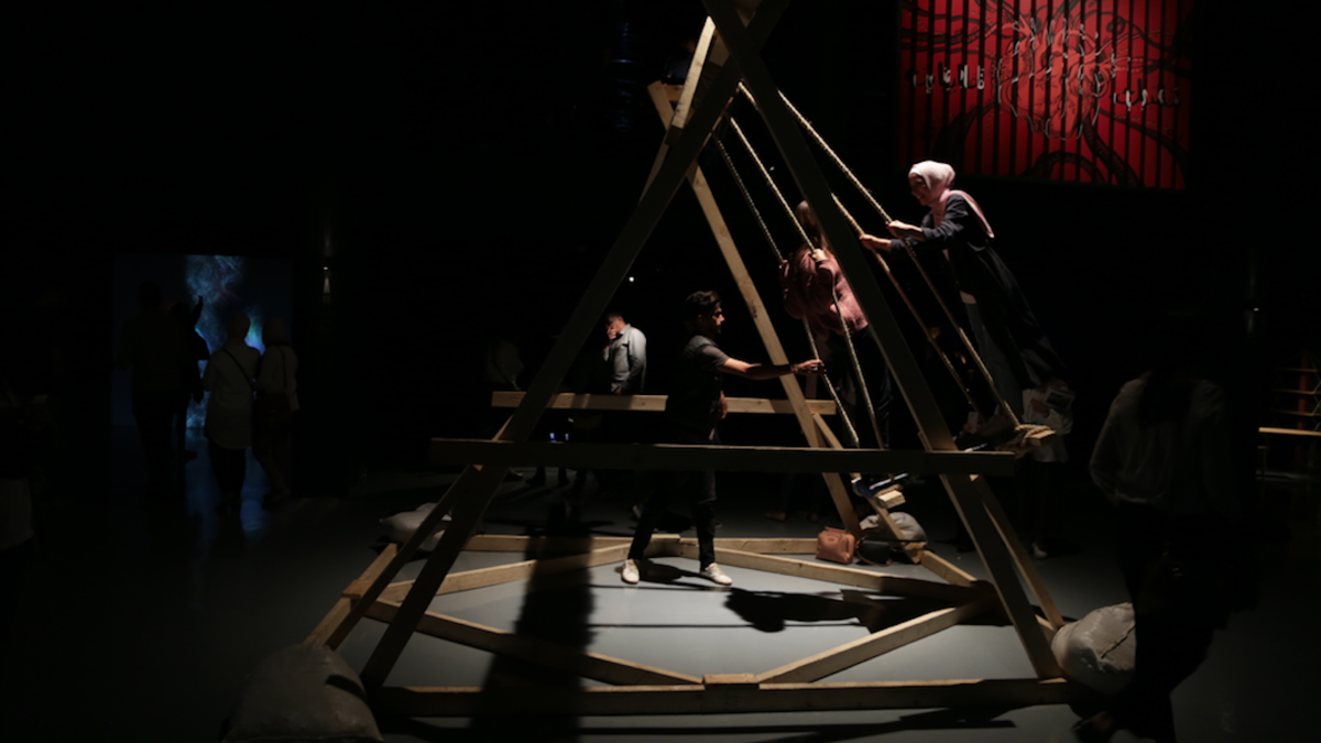 Two people are pushed on the interactive project Network of Swings. Created by 25-year-old Yasmeen Sabri one installation is located at the Amman Design Week, with another at the Zaatari Refugee camp. (Al Bawaba/Salim Essaid)