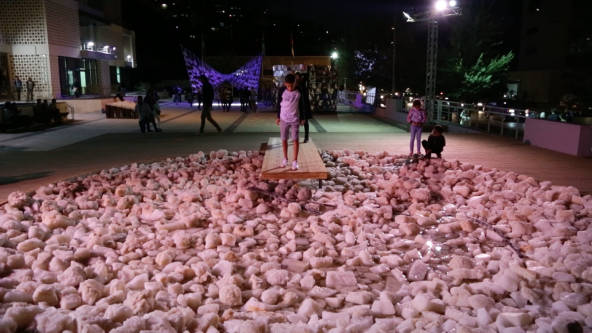 A boy stares down at his faint reflection in the salty water barely surfacing amongst a pond of rocks. A project by architect and urban designer representing the condition of the new ‘dry’ Dead Sea.  (Al Bawaba/Salim Essaid)