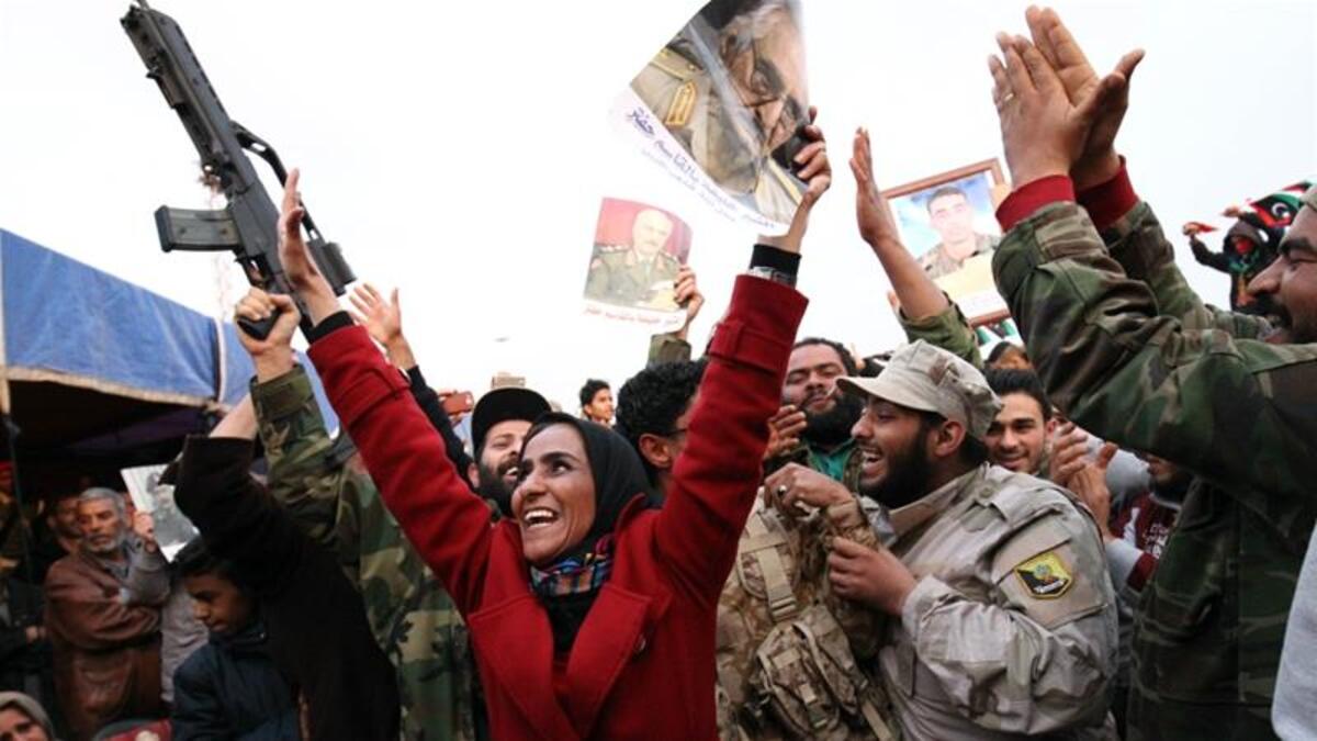 The Military Strongman:

After another brief spell in the US, Haftar returned to Libya and announced that the General National Congress, the country’s elected authority, had been dissolved. Those who opposed him described this as a coup attempt, however he denied the allegation.

(Photo: A woman waves a picture of Haftar. AFP)