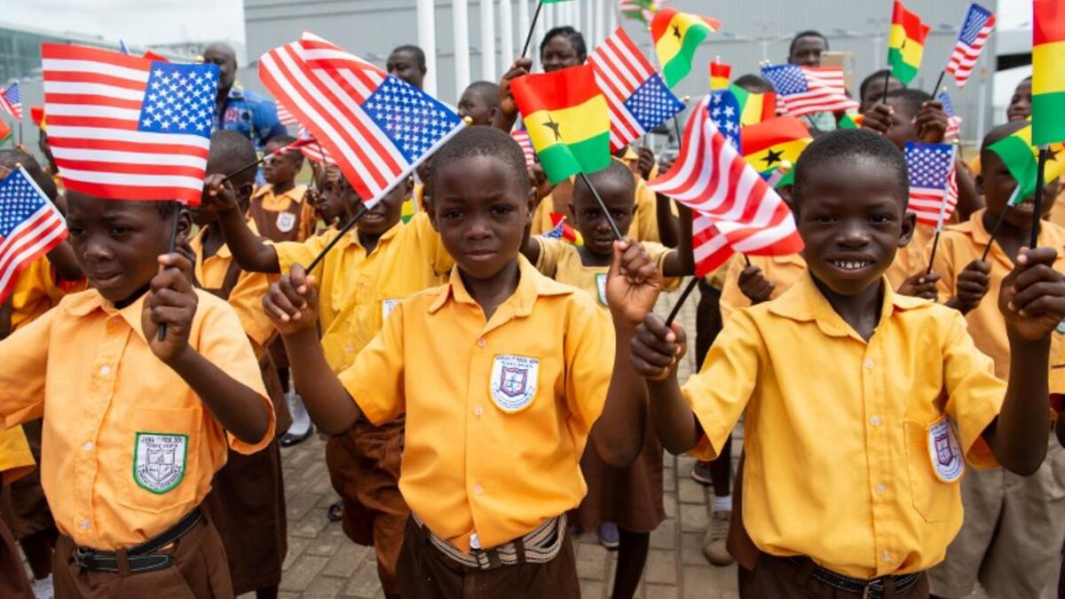 Children wave the American and Ghana flags for US First Lady Melania Trump during an arrival ceremony after landing at Kotoka International Airport in Accra October 2, 2018 as she begins her week long trip to Africa to promote her 'Be Best' campaign. (SAUL LOEB / AFP)