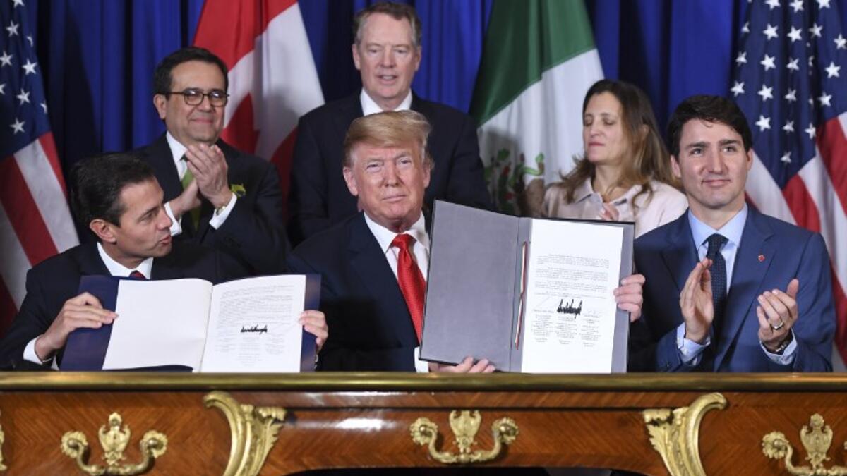 Mexico's President Enrique Pena Nieto (L) US President Donald Trump (C) and Canadian Prime Minister Justin Trudeau, sign a new free trade agreement in Buenos Aires, on November 30, 2018, on the sidelines of the G20 Leaders' Summit. 
SAUL LOEB / AFP