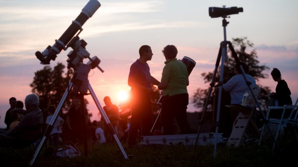 People gather as they wait for the sun to go down and the appearance of the 'Blood moon' in Vienna, Austria on July 27, 2018. The 'Blood moon' total lunar eclipse, is the longest of the 21st century.
GEORG HOCHMUTH / APA / AFP