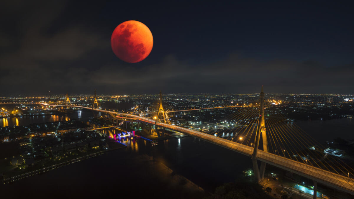 Lunar eclipse, super blood moon with view of the Bhumibol bridge and Curve of Chao Phraya River in Bangkok (Shutterstock)