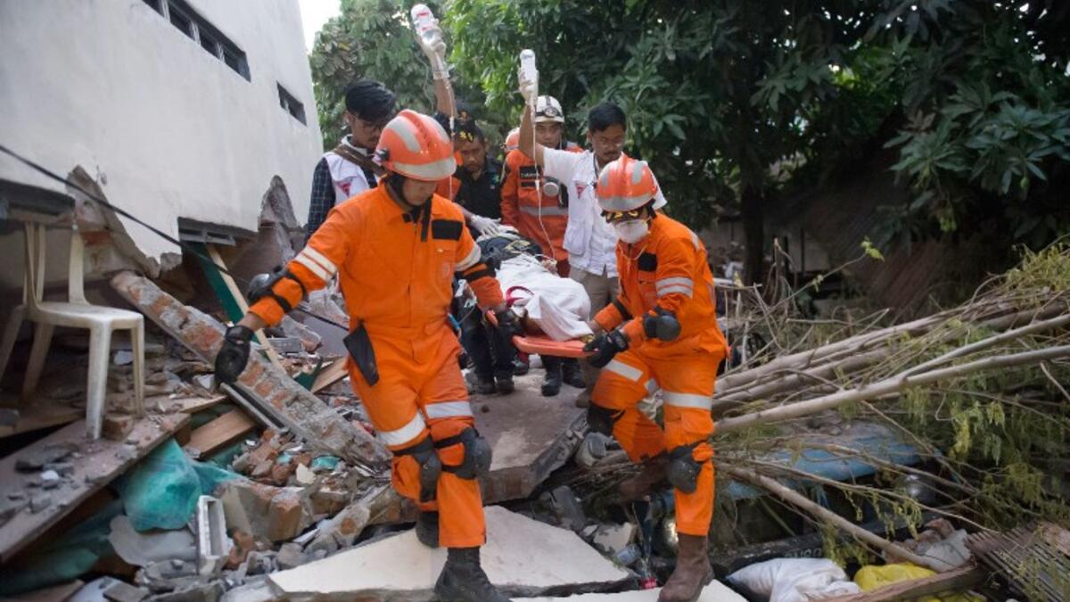 Rescue personnel evacuate earthquake survivor Ida, a food vendor, from the rubble of a collapsed restaurant in Palu, Indonesia's Central Sulawesi on September 30, 2018. (BAY ISMOYO / AFP)