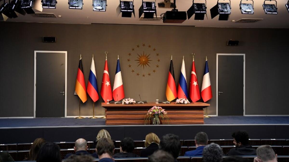 People sit in front of an empty stage ahead of a meeting during the "Four-way Istanbul summit on Syria", at Vahdettin Mansion in Istanbul, on October 27, 2018. (Bertrand GUAY / AFP)