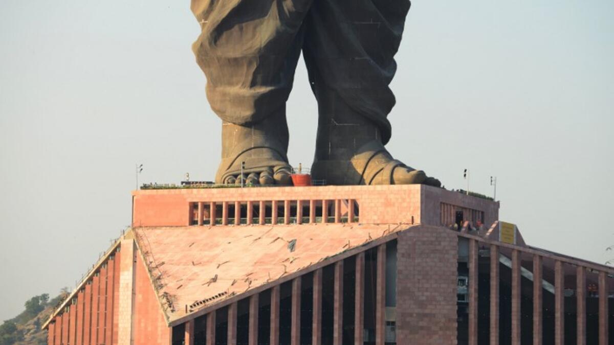 Indian construction workers are seen at the plimth structure the "Statue Of Unity". (SAM PANTHAKY / AFP)