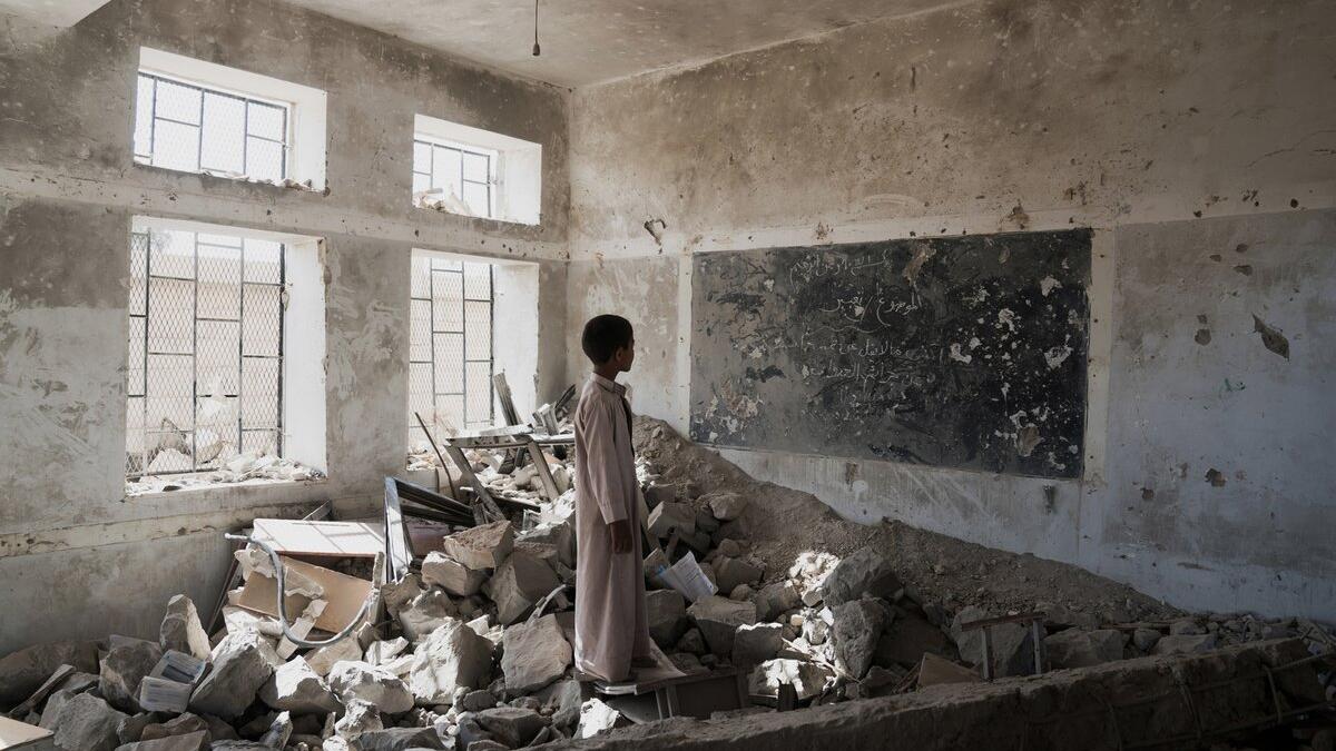 A pupil stands in the ruins of his former classroom, destroyed in June 2015 (Twitter)