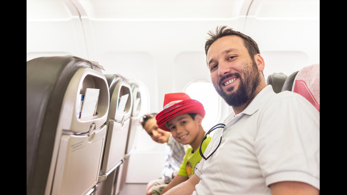 Arab man and kids plane seats looking up