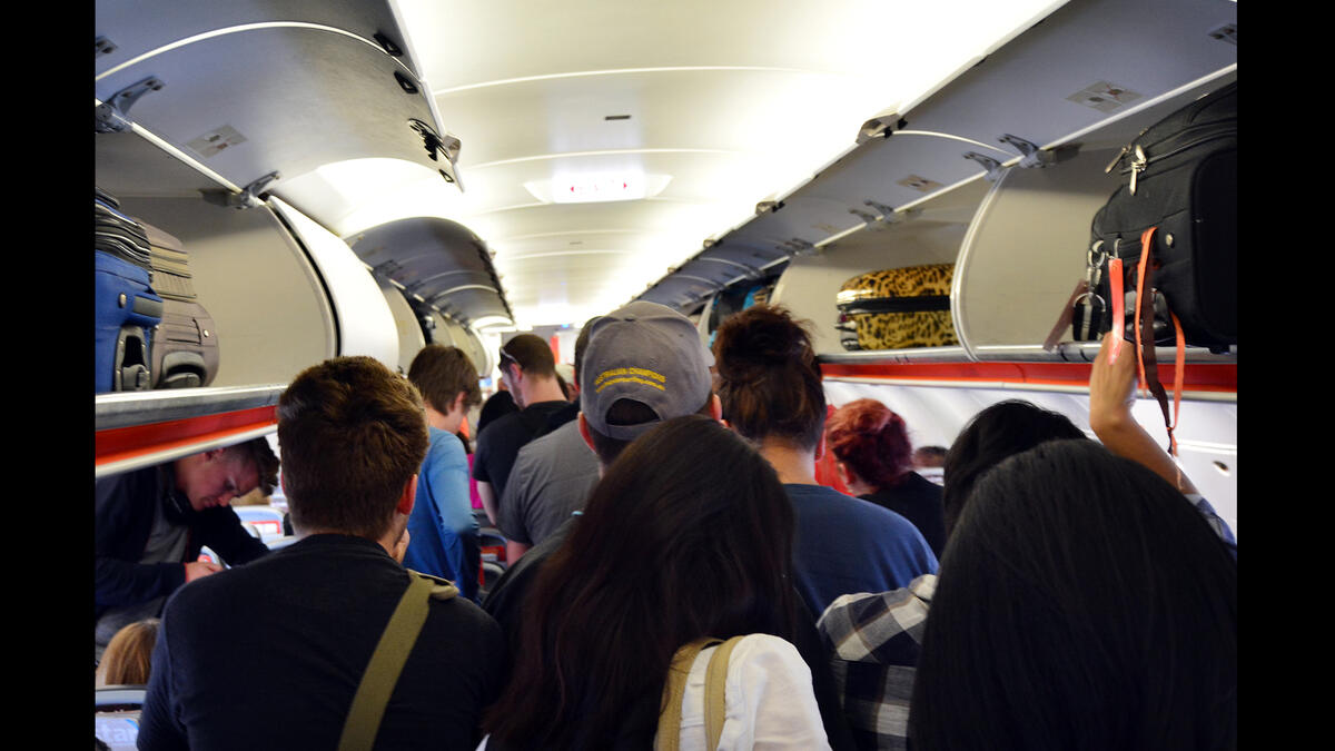 passengers standing in aisle airplane