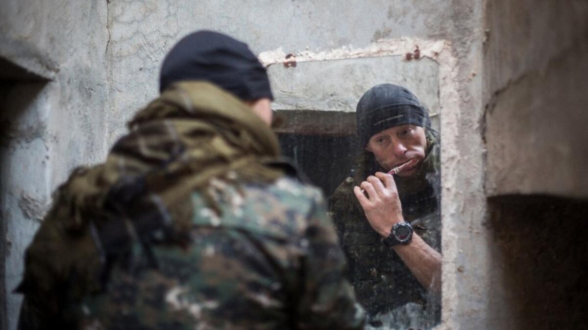 A 33-year old from New Zealand, nick-named by Kurdish fighters as ‘Hewal Welat,’ brushes his teeth on April 17, 2015 just outside Tal Tamr.