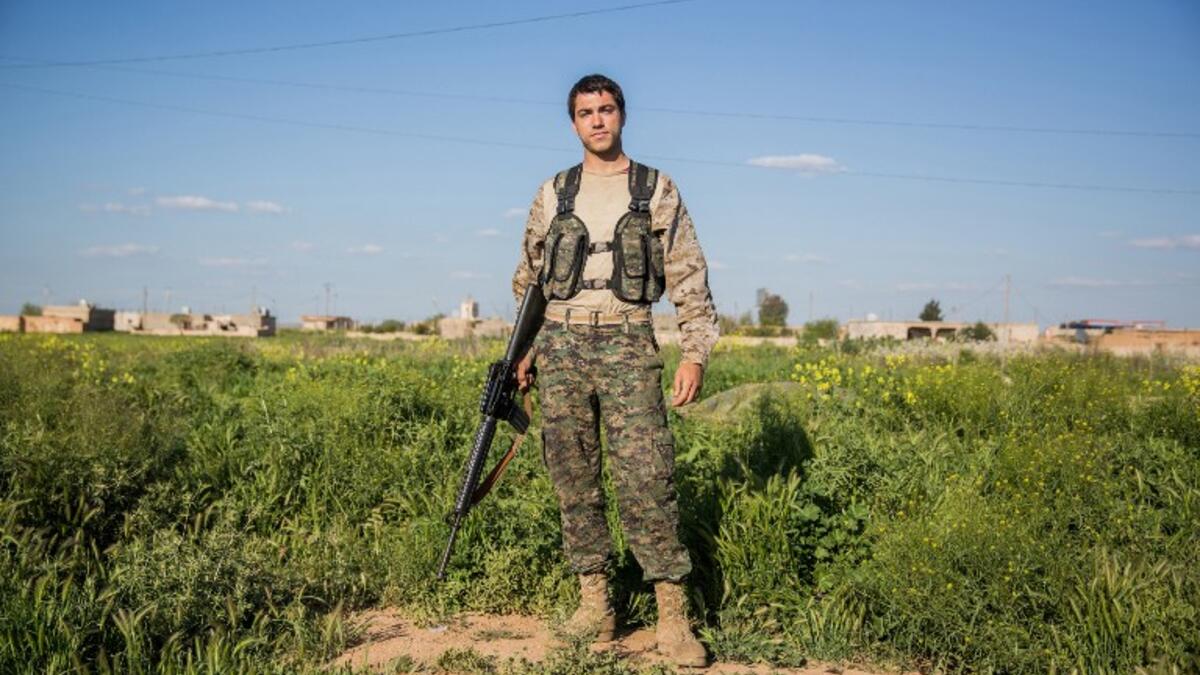 22-year old ‘Hewal Zagros’ from the US poses for a photo on April 14, 2015 on the outskirts of Tal Tamr.