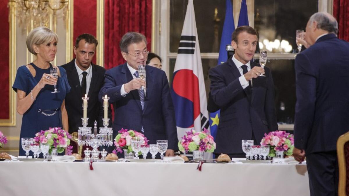 French President Emmanuel Macron (C-R), his wife Brigitte Macron (L) and South Korean President Moon Jae-in (C-L) toast during a state dinner at the Elysee Presidential palace in Paris, on October 15, 2018. 
(Christophe Petit-Tesson / POOL / AFP)