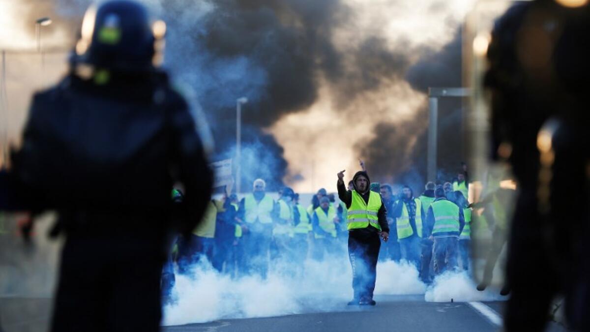 People stand as a man gestures in front of gendarmes on Caen's circular road on November 18, 2018 in Caen, northwestern France.
CREDITCHARLY TRIBALLEAU / AFP
