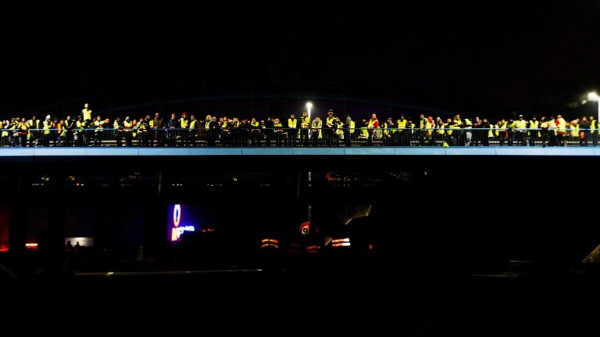 People stand in a bridge as they block the Caen's circular road on November 18, 2018 in Caen.
CHARLY TRIBALLEAU / AFP