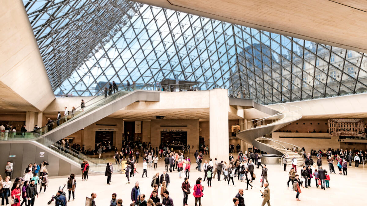 People at the main entrance of Louvre museum, under the famous glass Pyramid. (Shutterstock/ File)