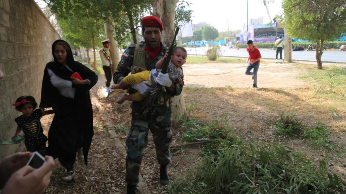 An Iranian soldier carrying a child at the site of an attack on a military parade in the southwestern Iranian city of Ahvaz on September 22, 2018. (Mehdi Pedramkhou / AFP / MEHR NEWS)
