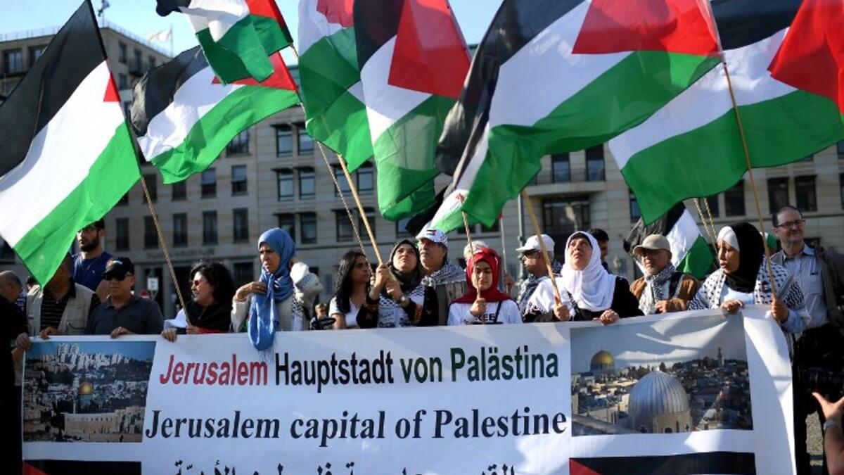 People wave Palestinian flags as they protest in front of the US embassy in Berlin on May 14, 2018. Britta Pedersen / dpa / AFP