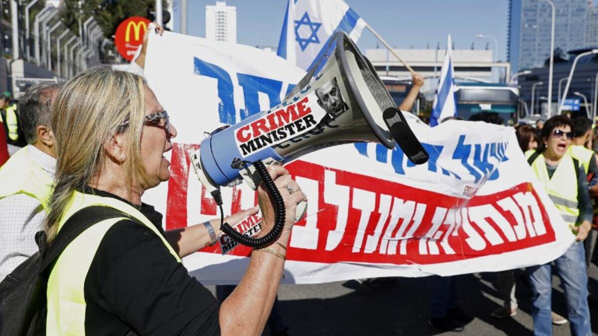 An Israeli protester wearing a yellow vest uses a loudspeaker to shout slogans during demonstrations against the rising cost of living on December 14, 2018.
JACK GUEZ / AFP