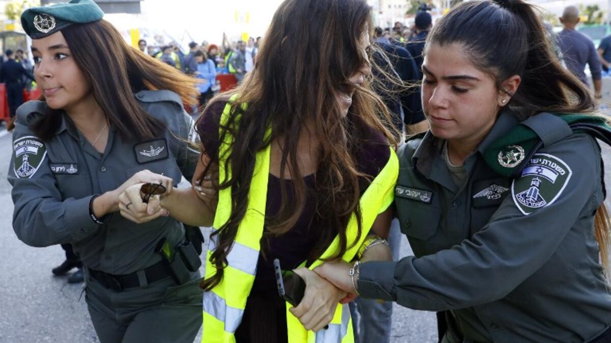 Members of the Israeli security forces arrest a protester wearing a yellow vest, during demonstrations against the rising cost of living on December 14, 2018.
JACK GUEZ / AFP