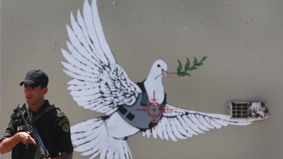 Street art by Banksy shows a dove with a bulletproof vest near his hotel in the occupied West Bank town of Bethlehem/ AFP