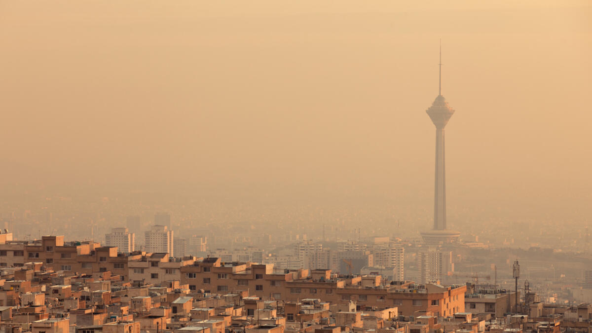 Residential buildings in front of Milad Tower in air-polluted skyline of Tehran illuminated with golden sunset, 435 meters (Shutterstock/File Photo)