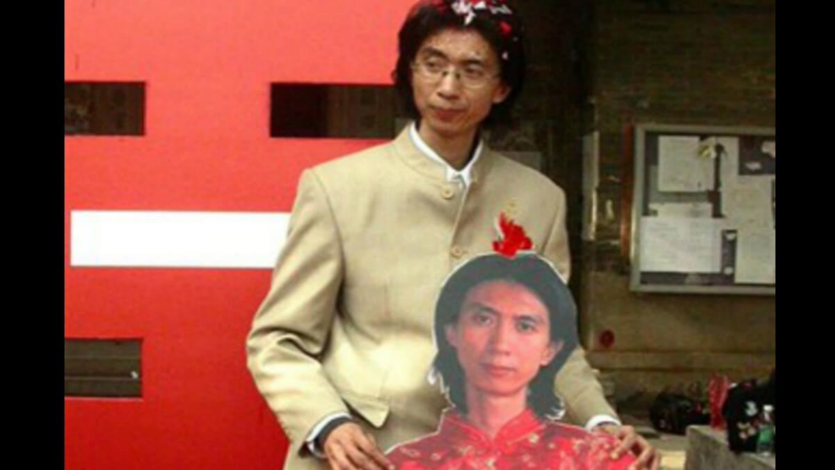 رجل صينى يقوم بالزواج من نفسه ، حيث احضر نموذجًا لشكله مرتديًا ملابس العروس