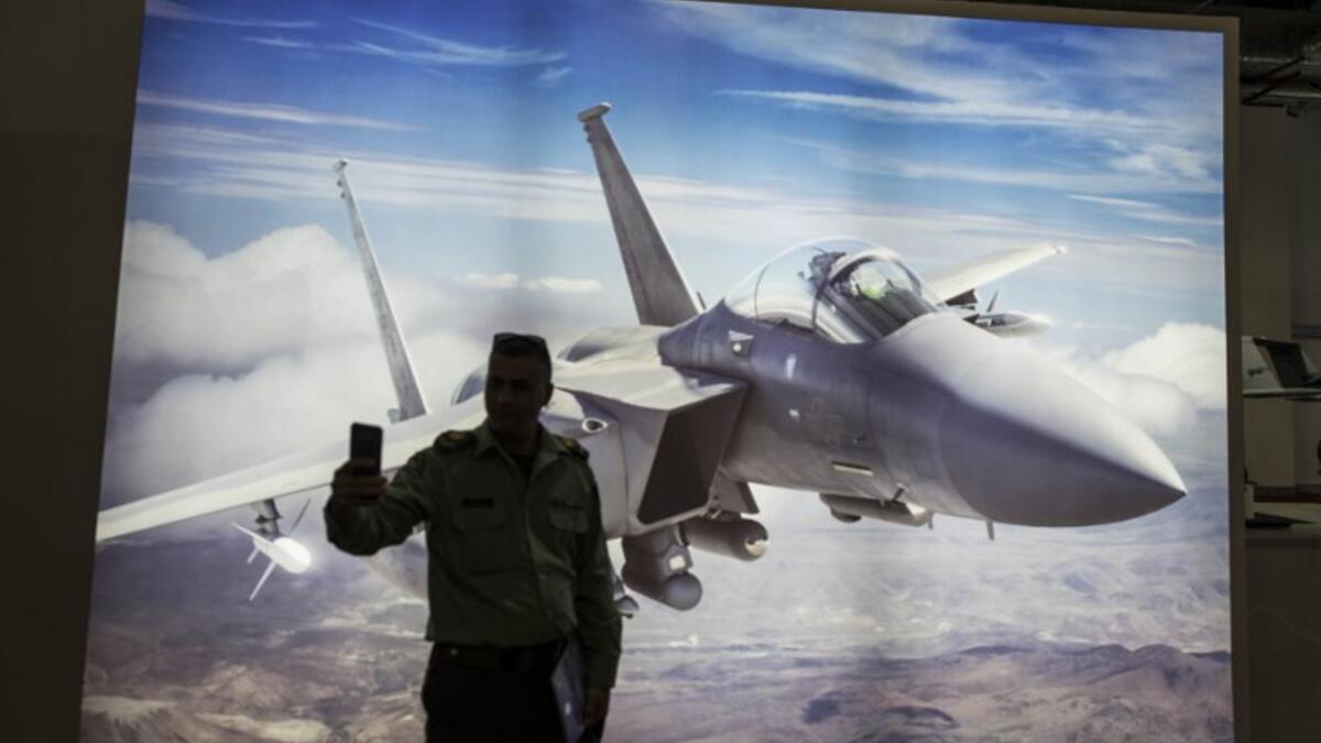 A Palestinian presidential guard takes selfie in front of a F15 jet fighter poster during Egypt’s first Service Defence Exhibition in Cairo on December 3, 2018, at the International Exhibition Center. 
Khaled DESOUKI / AFP