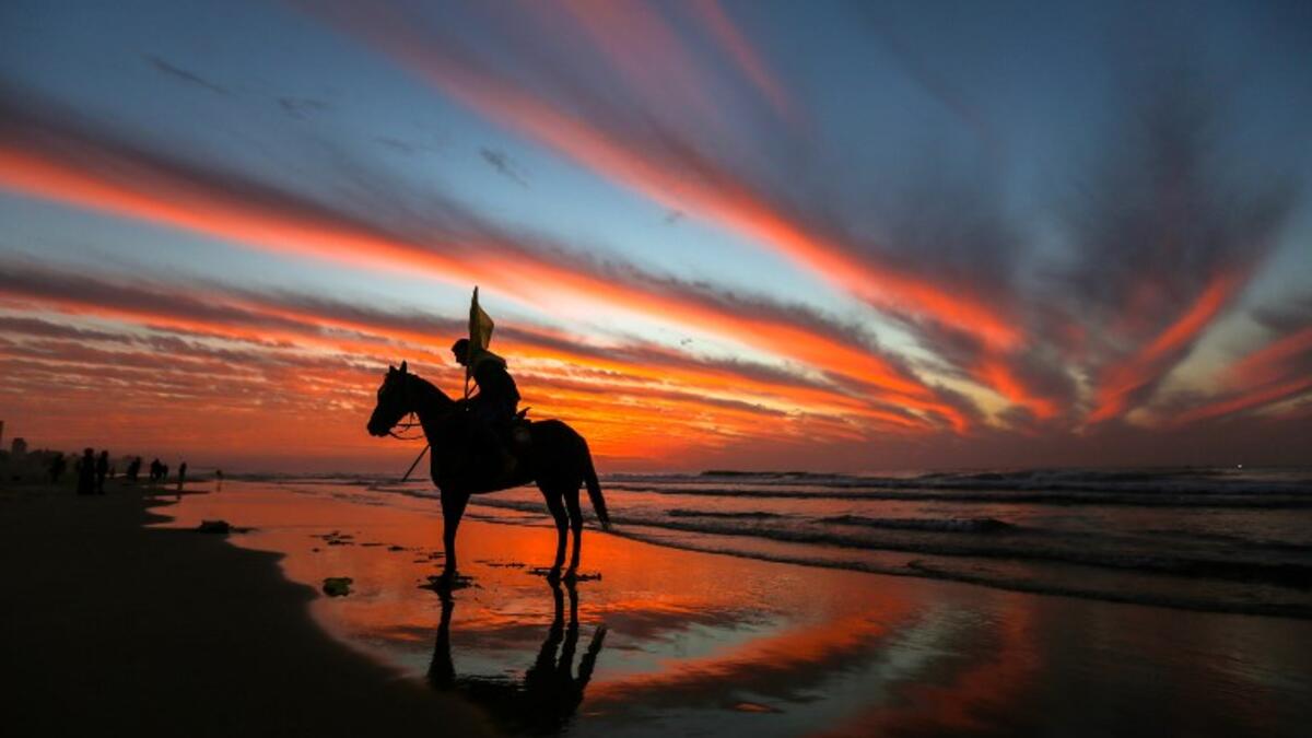 A Palestinian horseman rides on the beach at sunset west of in Gaza city on December 31, 2018. 
MAHMUD HAMS / AFP
