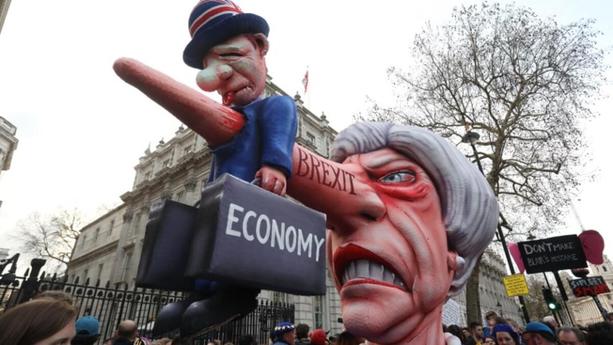 A puppet head of Britain's Prime Minister Theresa May spearing a representation of the British economy is positioned on Whitehall outside Downing Street after a march and rally organised by the pro-European People's Vote campaign for a second EU referendum in central London on March 23, 2019. 
Isabel INFANTES / AFP