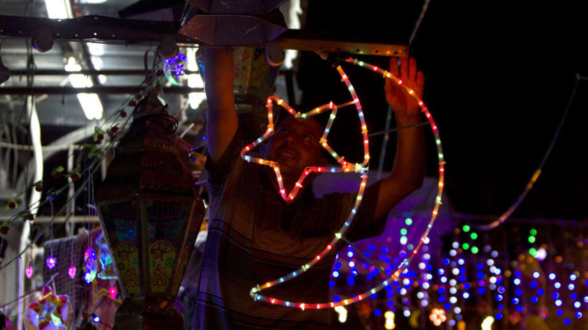 A Palestinian man decorates his shop near the entrance of the Al-Aqsa mosque compound, in the old city of Jerusalem, in preparation for Ramadan. 
AFP/ File Photo