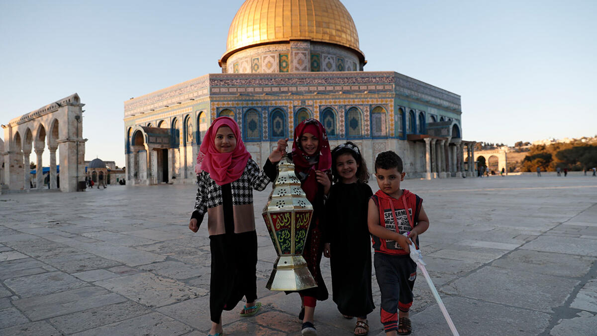 Palestinian girls pose for a picture with a Ramadan lantern in front of the Dome of the Rock at the Al-Aqsa Mosque compound in the Old City of Jerusalem. 
Ahmad Gharabli/AFP