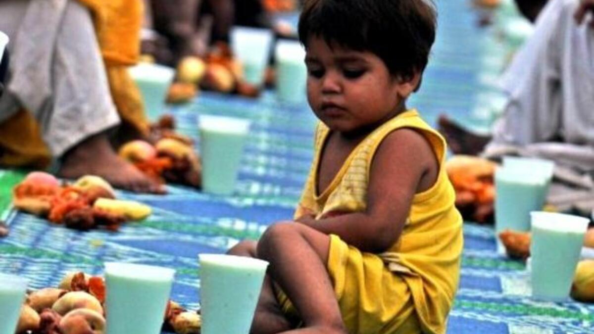 Pakistan's Karachi: Children congregate in a public tent setting to mark the break of fast food stuff, prepared for Iftar for fellow Pakistani 
Muslims.