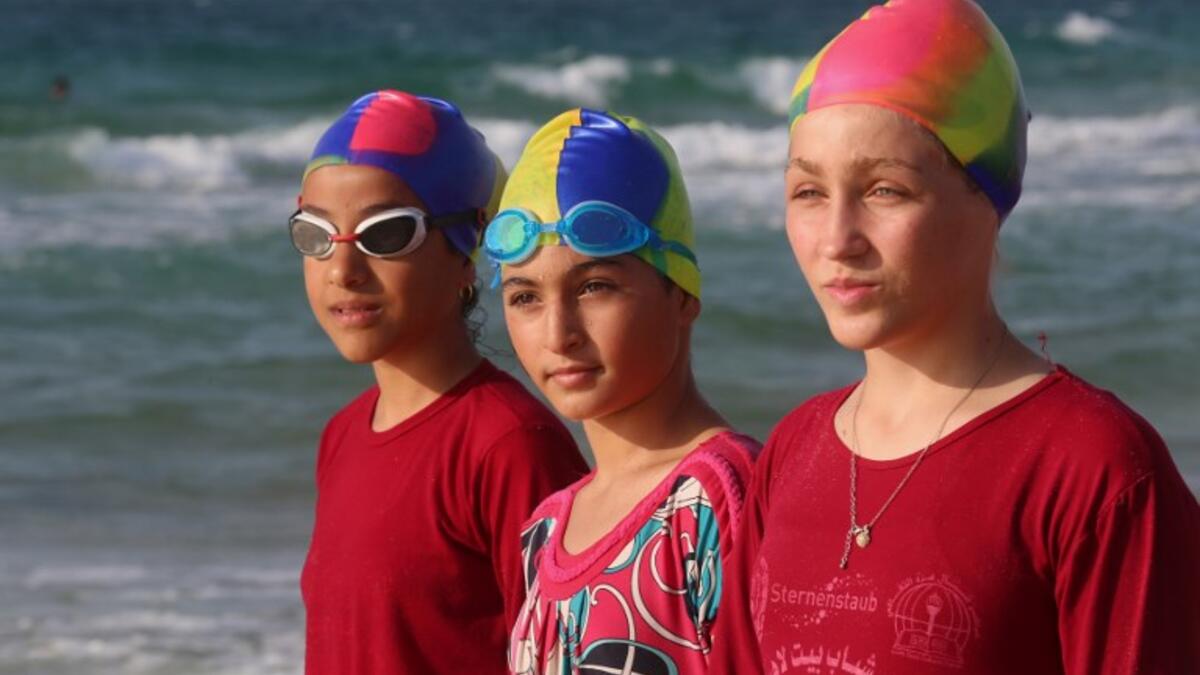 Young Palestinian members of a swimming club, prepare to swim during training session. (SAID KHATIB / AFP)