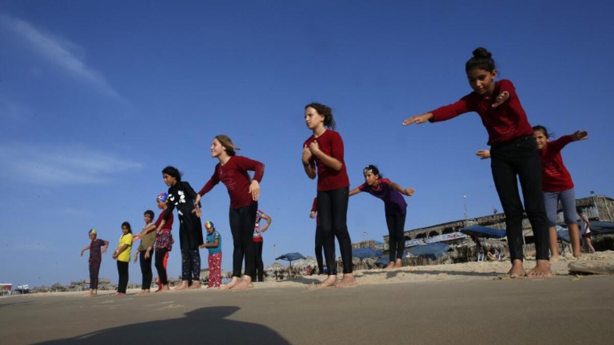 Young Palestinian members of a swimming club, participate in a group excercise on the beach during a training session in Beit Lahia in the northern Gaza Strip. (SAID KHATIB / AFP)