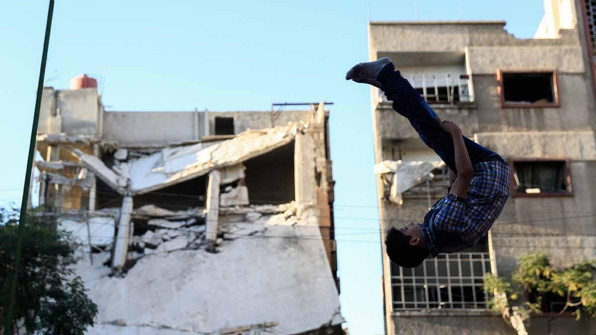 A boy head over heals in Douma, September 2016. The rebel-held city has been under blockage by Syrian government forces since 2013, causing shortages in food and medical supplies.