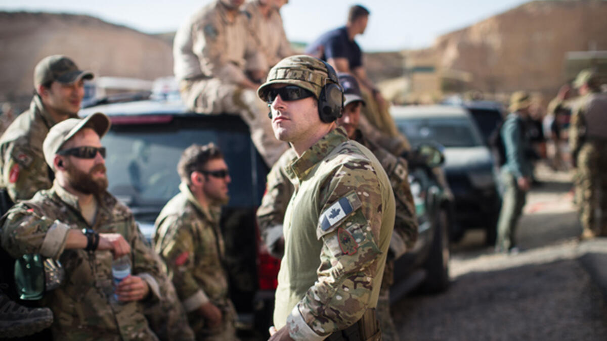 Members of the American and Canadian teams cheer together and watch the remaining teams compete in the "Top Gun" event at the seventh annual Warrior Competition. “It’s a little surreal,” one American soldier said. “You never know what guys you see here today might be fighting each other in a couple of years.”
