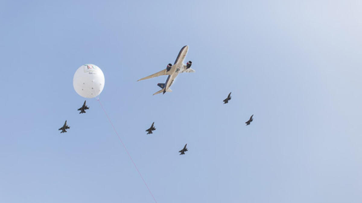 A Royal Jordanian commercial plane flies overhead, flanked by fighter jets from Jordan's air force as part of celebrations marking the centennial of the Great Arab Revolt in Amman.