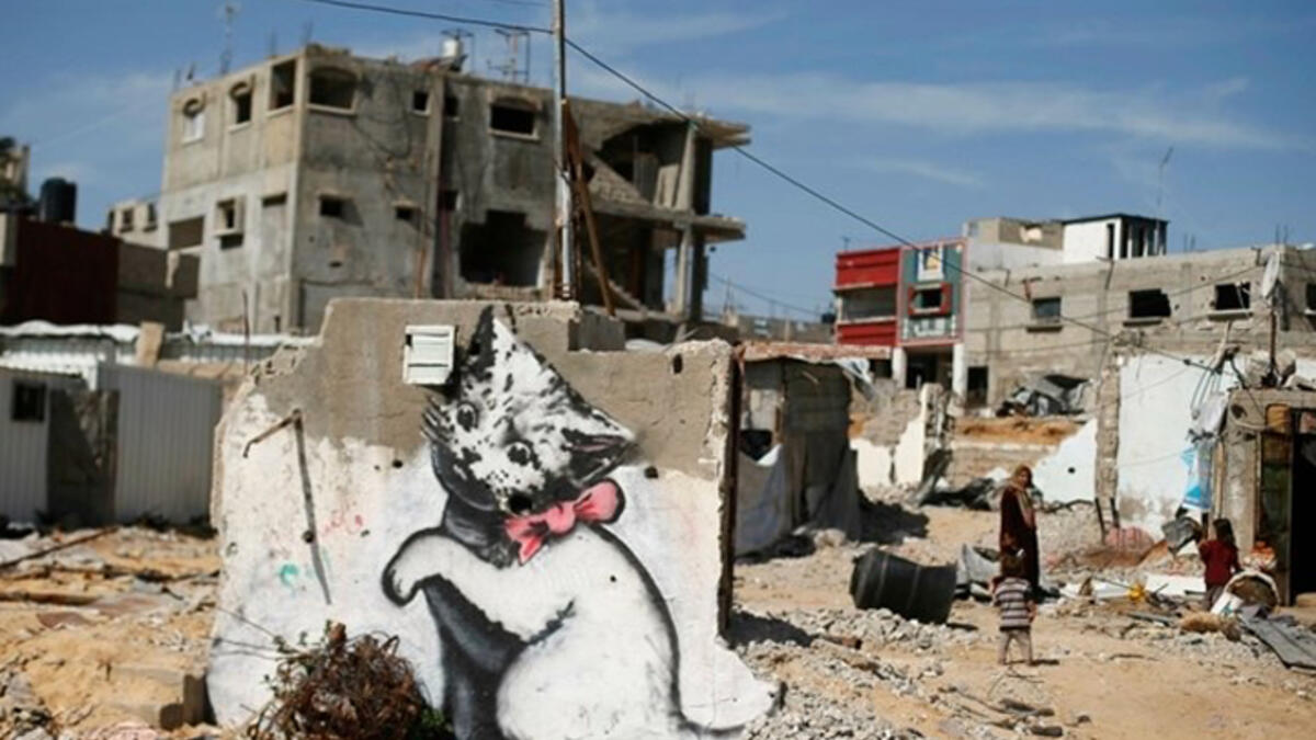 Banksy’s cute kitty plays with a ball of tangled steel (Gazan “yarn”), a jarring contrast to the destruction around him. Says the artist on his website, "A local man came up and said 'what does this mean?' I explained I wanted to highlight the Gaza destruction by posting photos, but on the internet people only look at pictures of kittens."