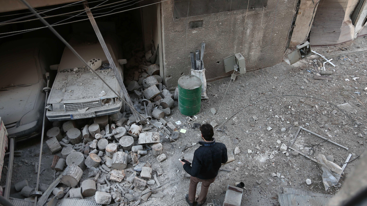 A Syrian civilian inspects the damage following government bombing in the rebel-held town of Hamouria, in the besieged Eastern Ghouta region on the outskirts of the capital Damascus, on Feb. 19, 2018. 
(ABDULMONAM EASSA / AFP)