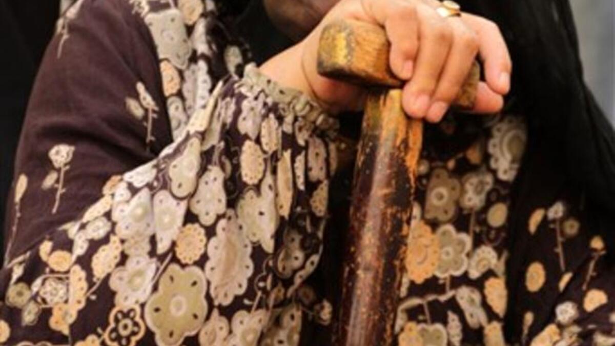 An Egyptian woman holds an election flyer depicting candidate Abdul Moneim Amara as she sits outside a polling station in Cairo's Imbaba neighborhood, as the nation of some 41 million eligible voters goes to the polls.