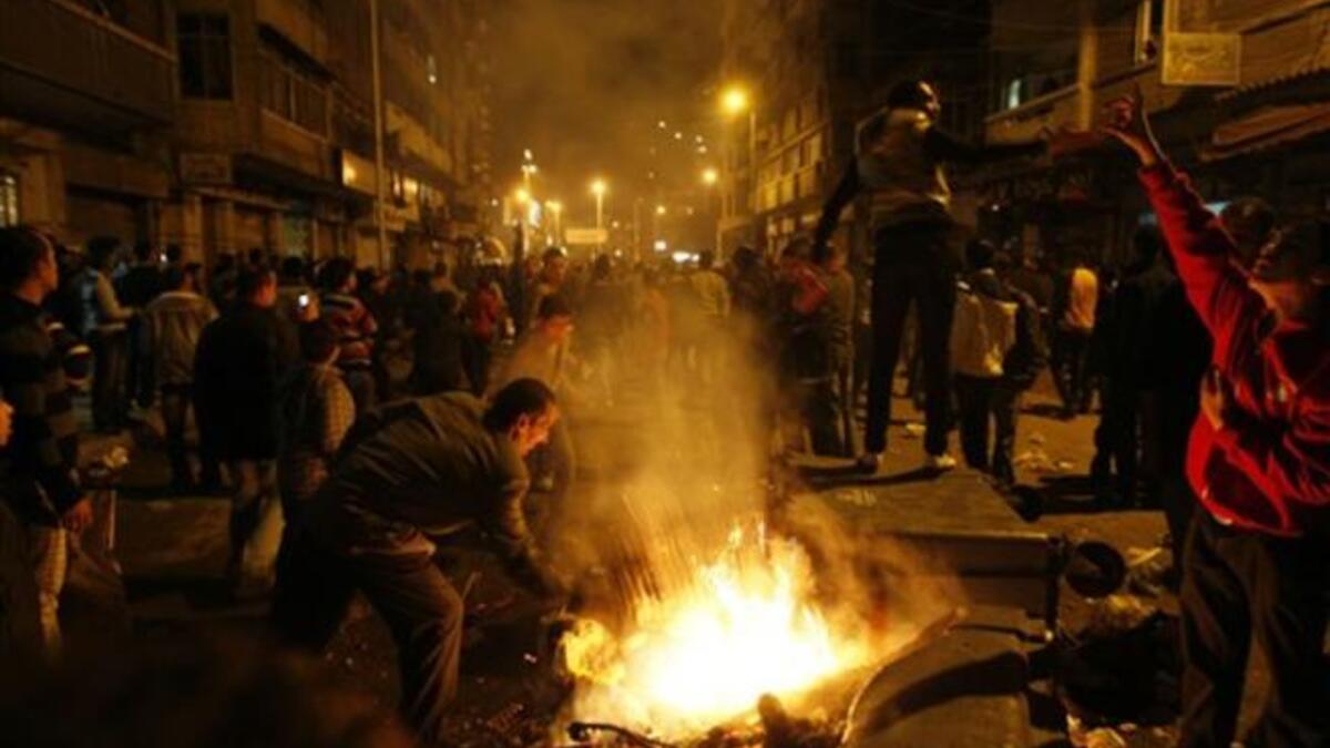 Egyptian Christians burn trash containers during a protest late near the Al-Qiddissine church.