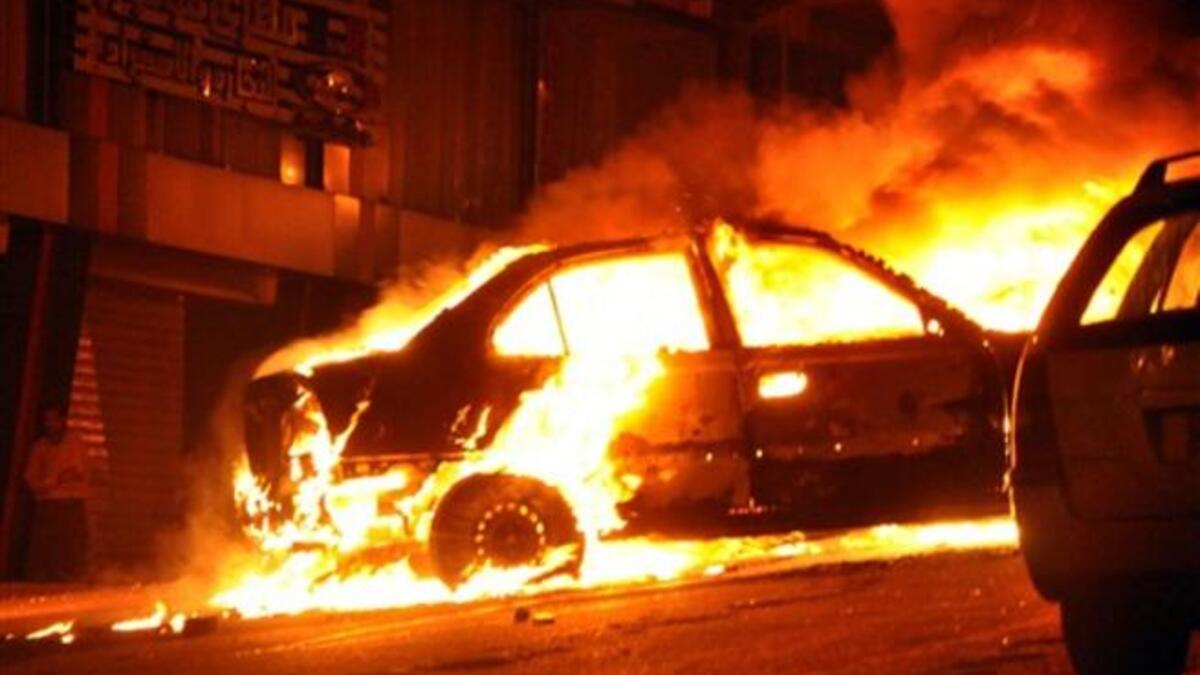 A vehicle burns following a car bomb attack outside the Al-Qiddissine (The Saints) church.