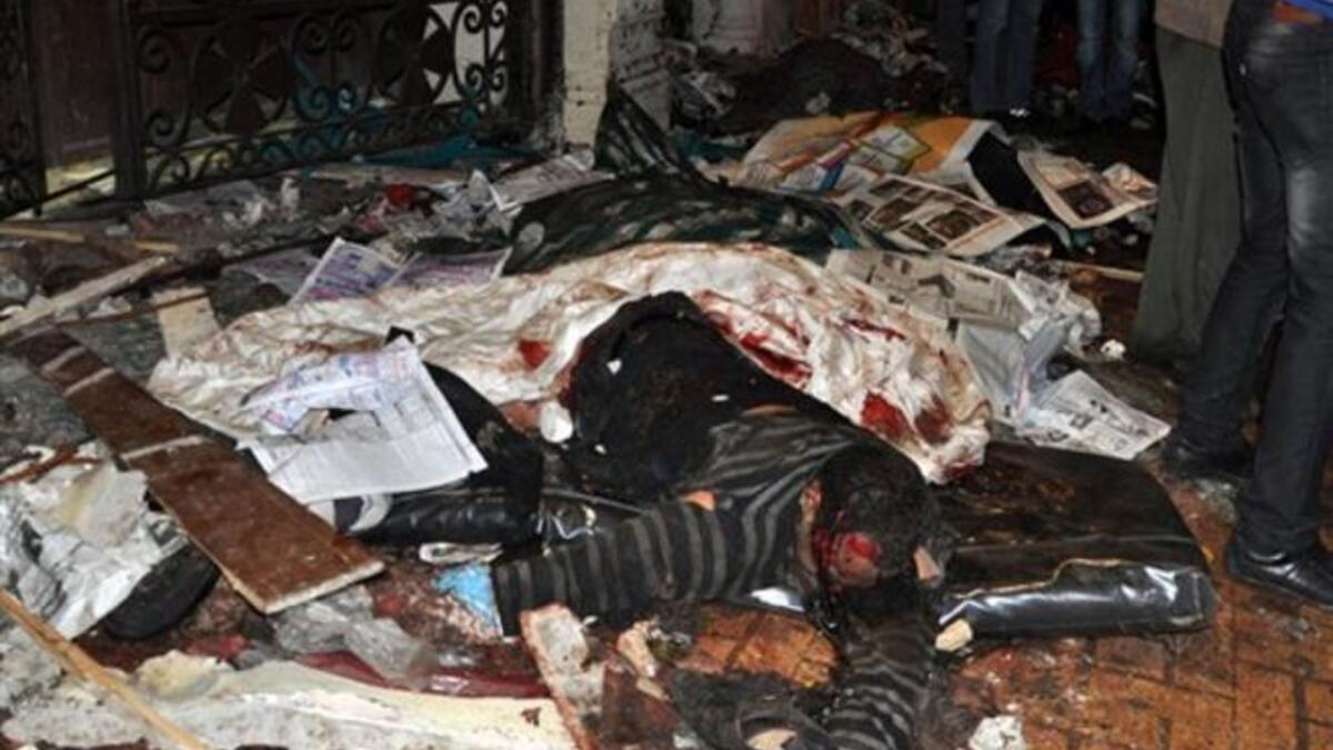 The body of an Egyptian Coptic man is seen on the ground following a car bomb attack outside the Al-Qiddissine church.