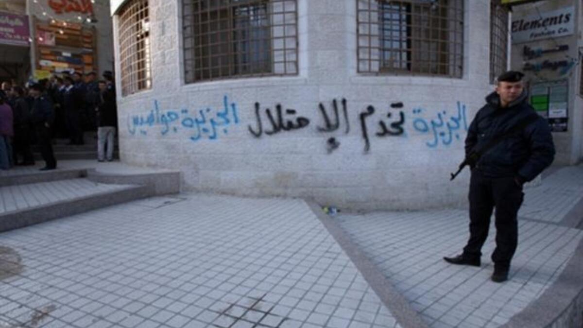 A Palestinian policeman stands guard outside the offices of the pan-Arab news channel Al-Jazeera.
