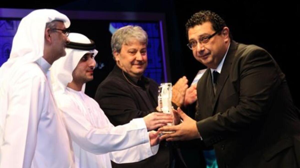 Sheikh Said bin Mohammed bin Rashed al-Maktoum (2nd L) hands the best actor award to Egypt's Maged al-Kidwany.