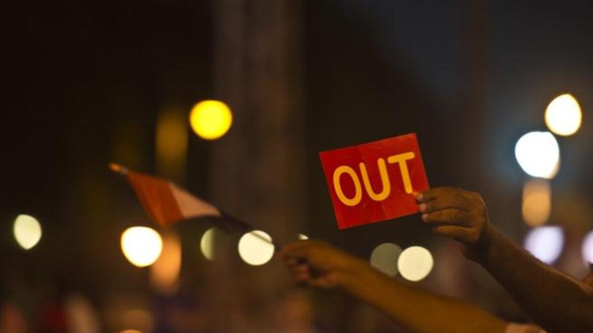 An Egyptian man holds up a red card against the country's Islamist President in front of the presidential palace in Cairo (AFP)