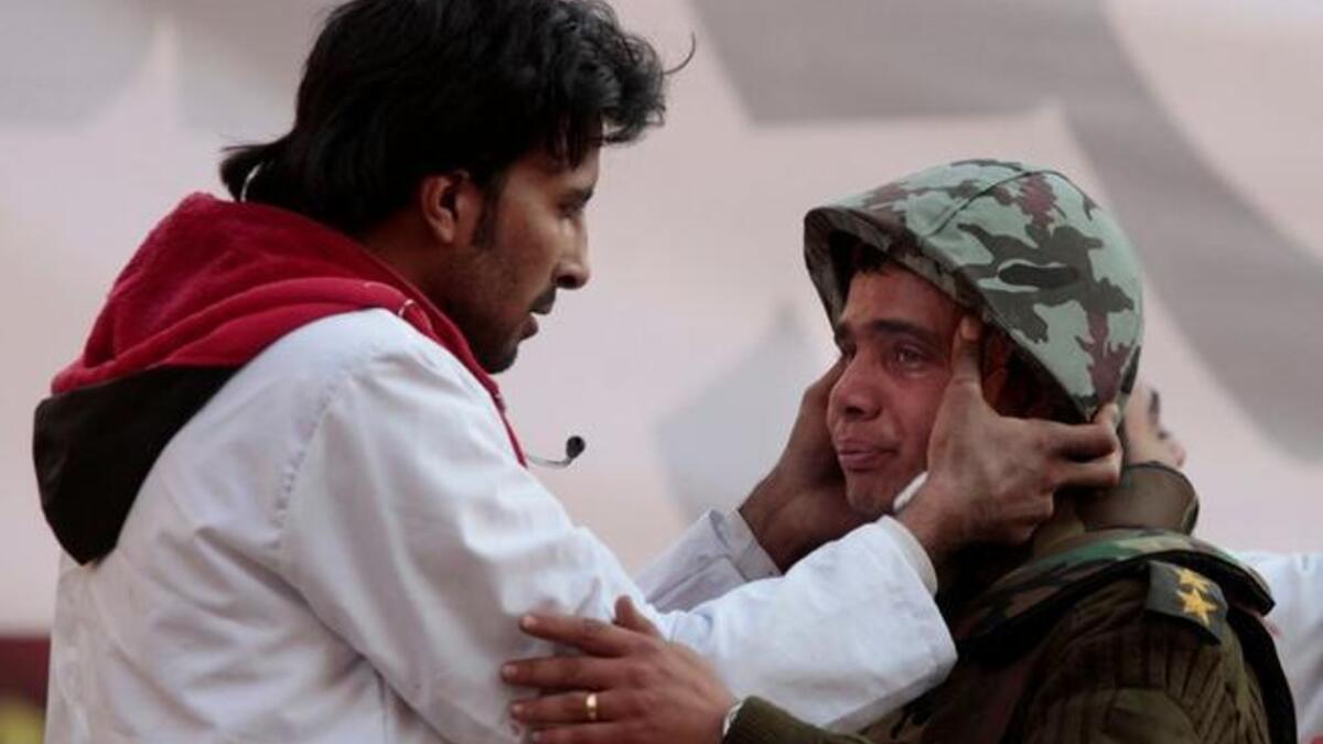 A People's Doctor is applying his healing hands to an Egyptian soldier who cries guilty tears of apology for not having been able to protect his people from the pro-Mubarak stampede.