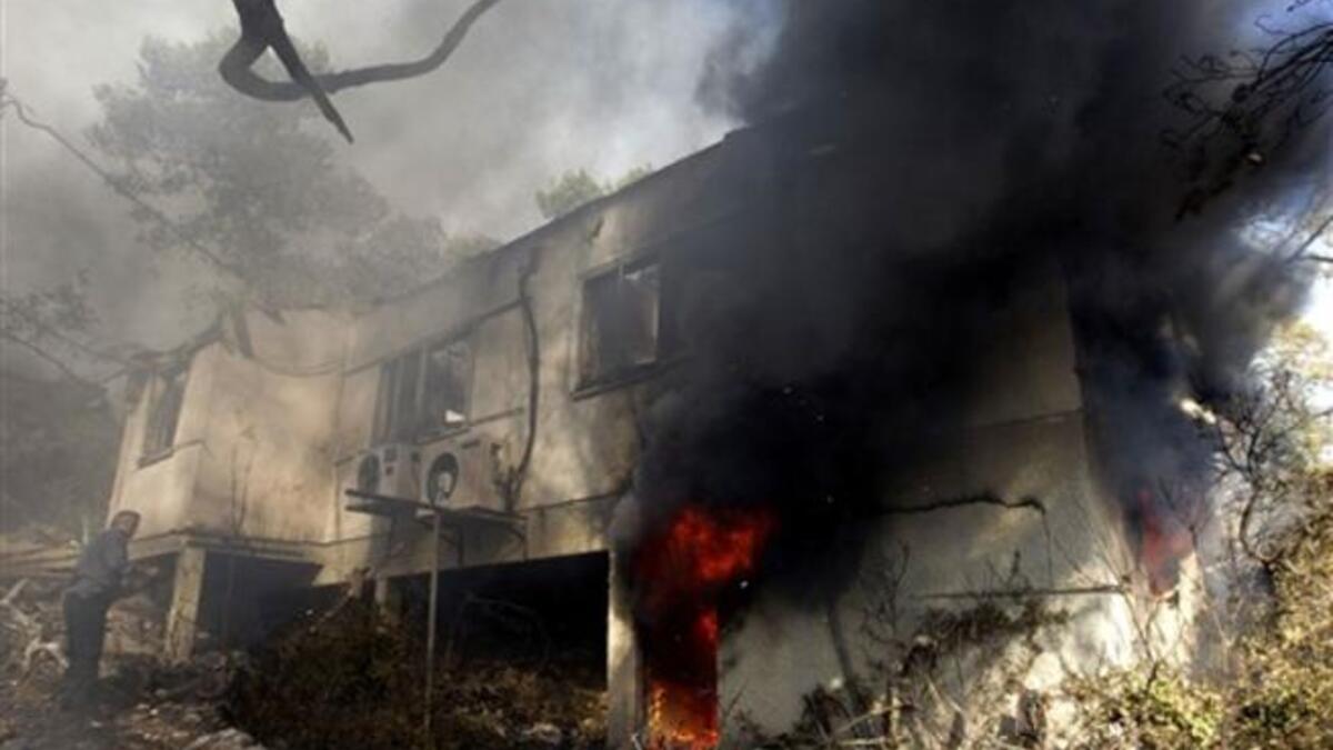 An Israeli firefighter prepares to douse a burning house in the Artists; village of Ein Hod near the northern city of Haifa.